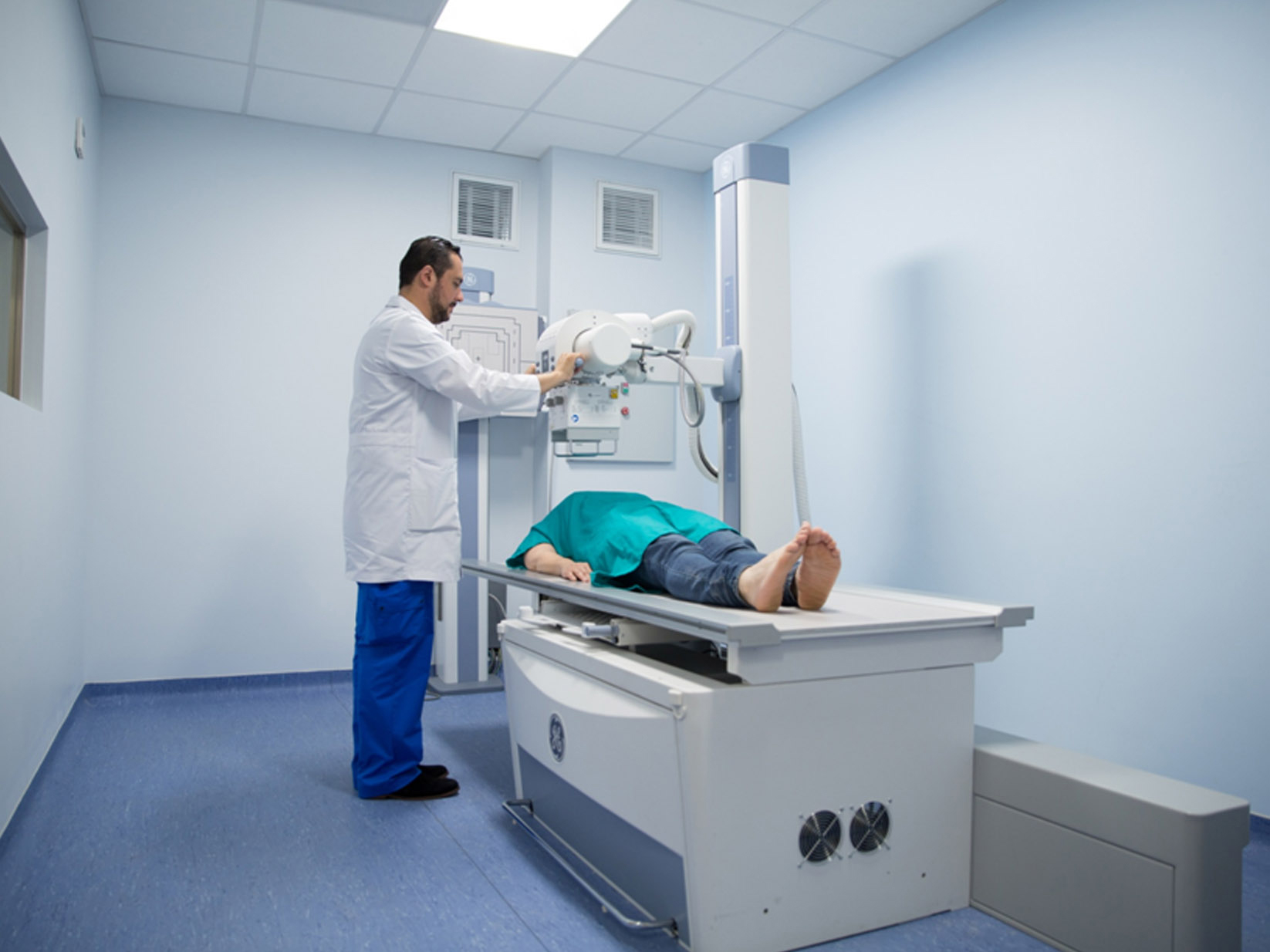 Medical technician with a patient who is lying on an imaging maching at the OSME clinic