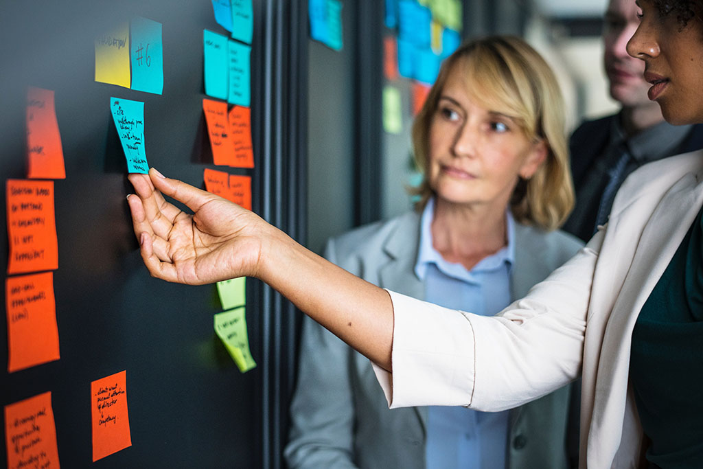 People brainstorming ideas at a board with sticky notes