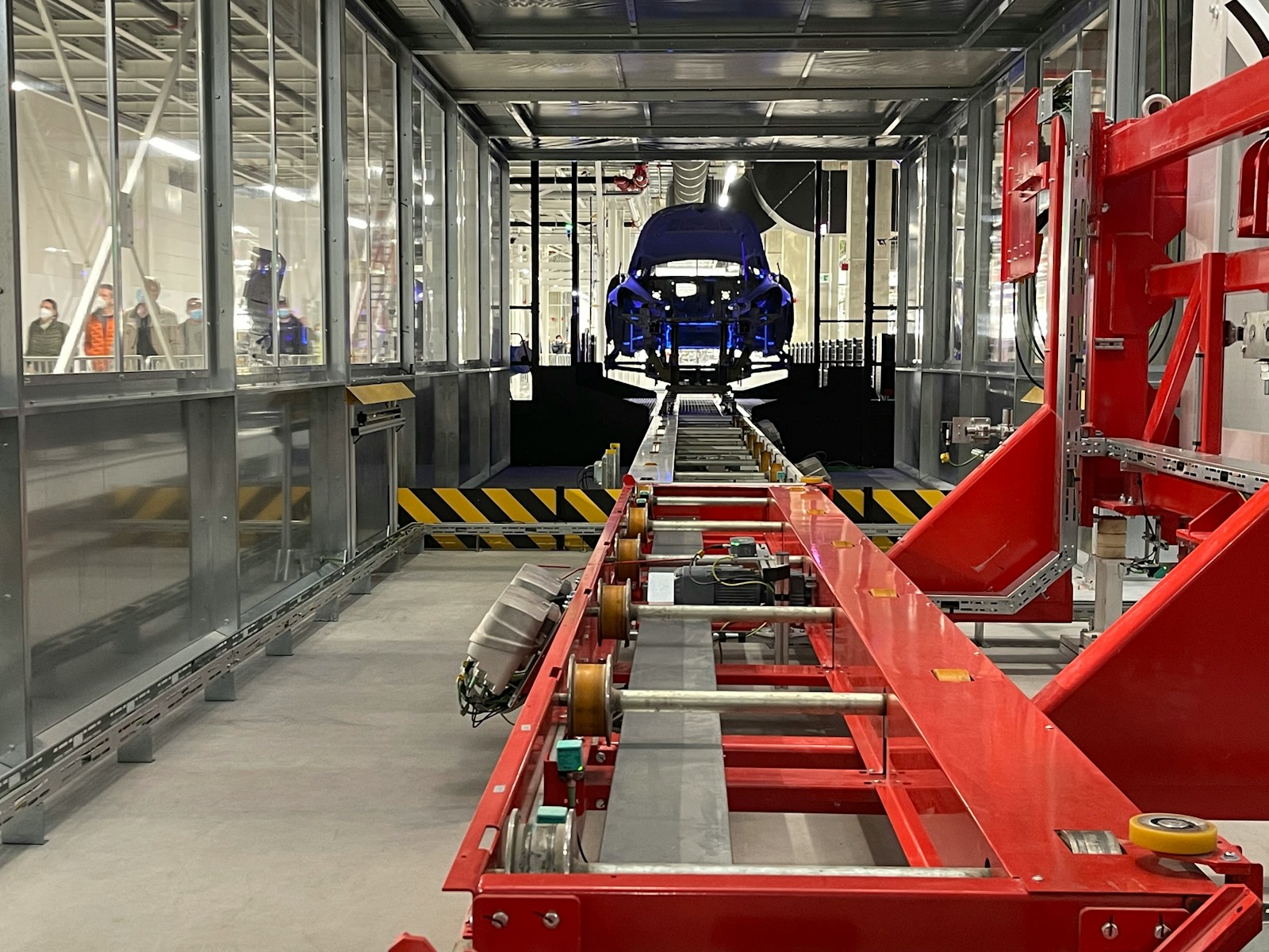 a car being built in a large factory on an assembly line